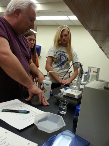 Pleasanton Students Breann Zimmer and Kara Dauel work with local researcher, Dr. Frank Kovacs, Biochemistry professor at the University of Nebraska-Kearney.  The student research team are calibrating a pH sensor to determine the pH levels of the experimental solution.